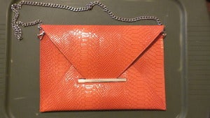 Image of Orange snake print clutch
