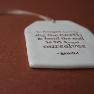 Image of ceramic quote tag - to forget how to dig the earth