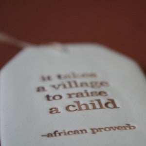 Image of ceramic quote tag - village to raise a child