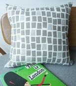 Image of city windows cushion in grey on white linen