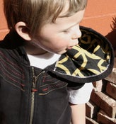 Image of sleeveless plaid cat ear hoodie with gold peace signs on back and in hood