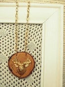 Image of Gold Deer Head Necklace on Wood Slice