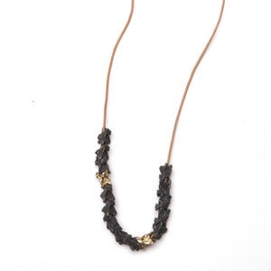 Image of thirteen oxidized silver & two 14k vertebrae on wax-coated cotton (P20B10sil14k28)