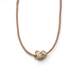 Image of 14k gold single vertebrae on wax-coated cotton w/ 14k gold caudal vertebrae closure (P021B1014k)