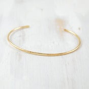 Image of thin simple gold forged cuff