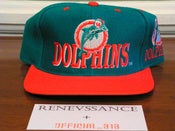 Image of VINTAGE DEADSTOCK MIAMI DOLPHINS AJD "LOGO / ALL OVER TEXT" SNAPBACK CAP HAT