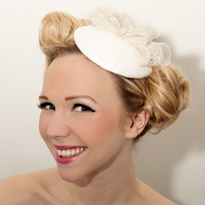 Image of Bridal fascinator, decorated with embellished bows and a solid silver good luck charm.