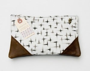Image of large charcoal + cream brushstroke crosses print clutch with leather corners