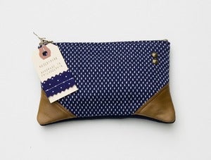 Image of -SOLD OUT- a small navy +white dot zipper pouch with leather corners
