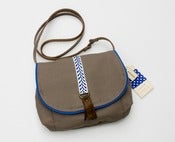Image of --S OL D O U T -- small cross-body bag in taupe with royal + white woven trim and leather tassel