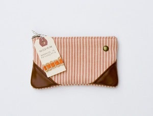 Image of --SOLD OUT-- a small coral + sand zipper pouch with leather corners and a METAL zipper