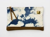 Image of zipper clutch in hand bleached denim 